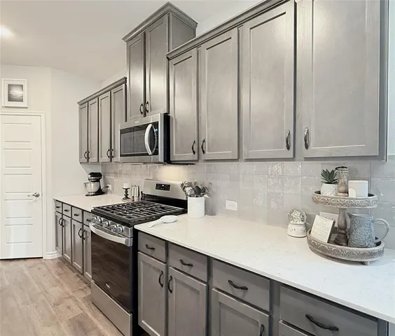 a kitchen with stainless steel appliances a sink stove and cabinets