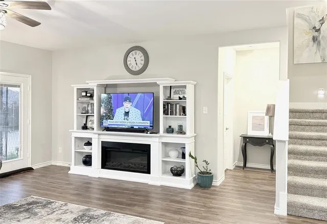 a view of a livingroom with wooden floor and a fireplace
