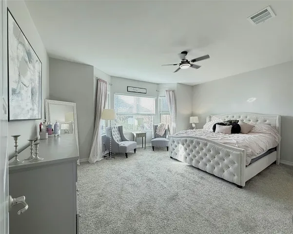 a spacious bedroom with a bed couch and a window