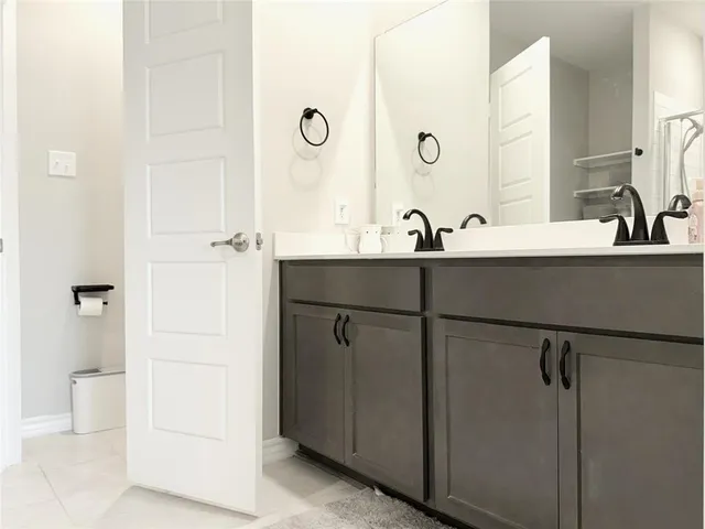 a bathroom with a double vanity sink a toilet and a mirror