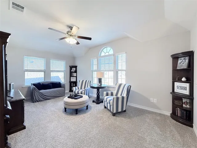 a living room with furniture a bed and a large window