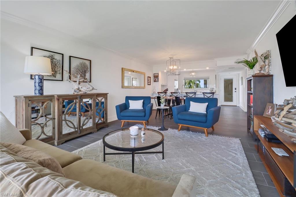 Living room with crown molding and an inviting chandelier
