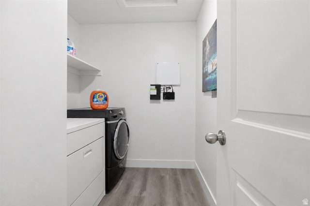 1213 West 1820th Street South Logan, UT 84321 - Photo 13 of 18 Laundry area featuring wood-finish flooring, white walls, and a built-in shelf