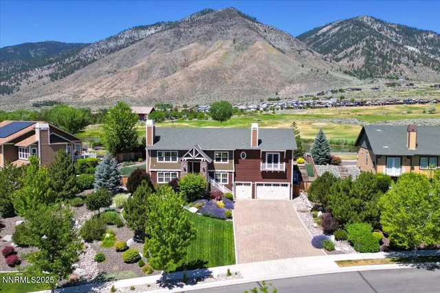 an aerial view of a house with a garden and lake view
