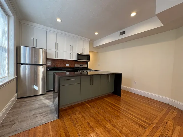 a kitchen with a refrigerator and a stove top oven