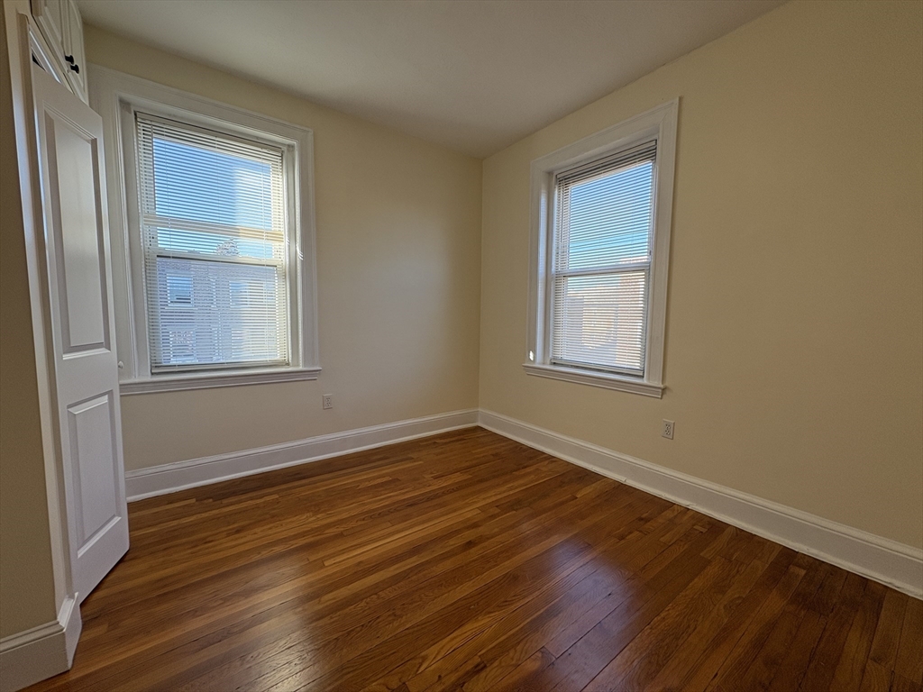 73 Thatcher Street, Unit 301 Brookline, MA 02446 - Photo 12 of 15 a view of an empty room with wooden floor and a window