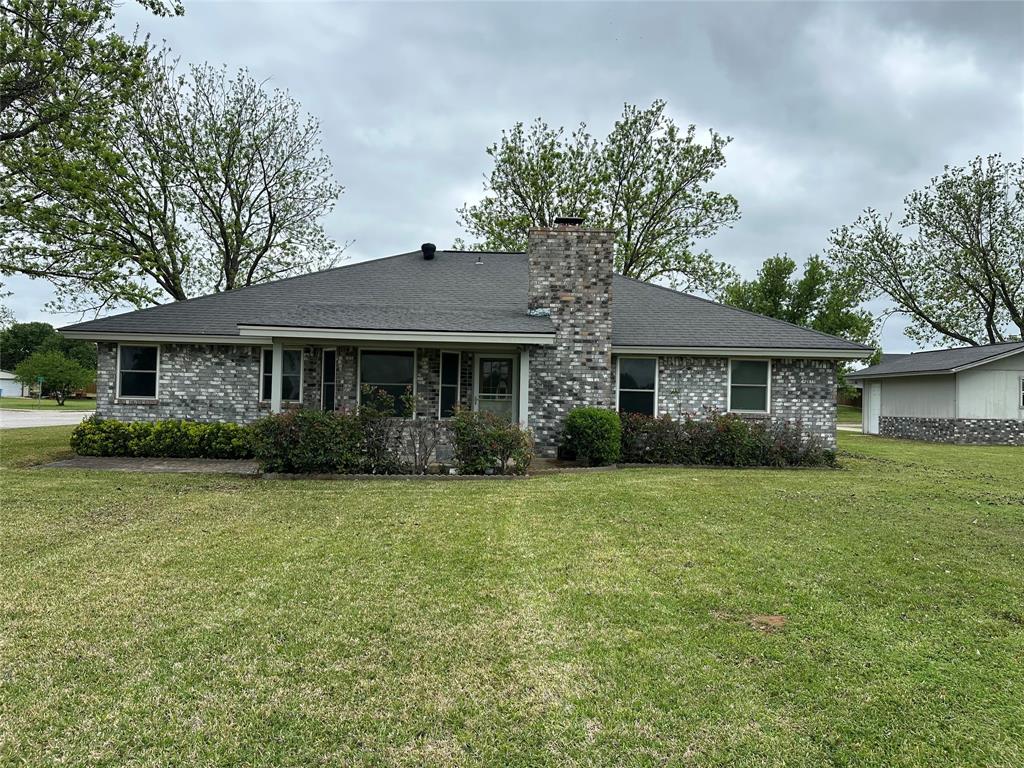 101 Player Street Comanche, TX 76442 - Photo 4 of 4 a front view of a house with a garden