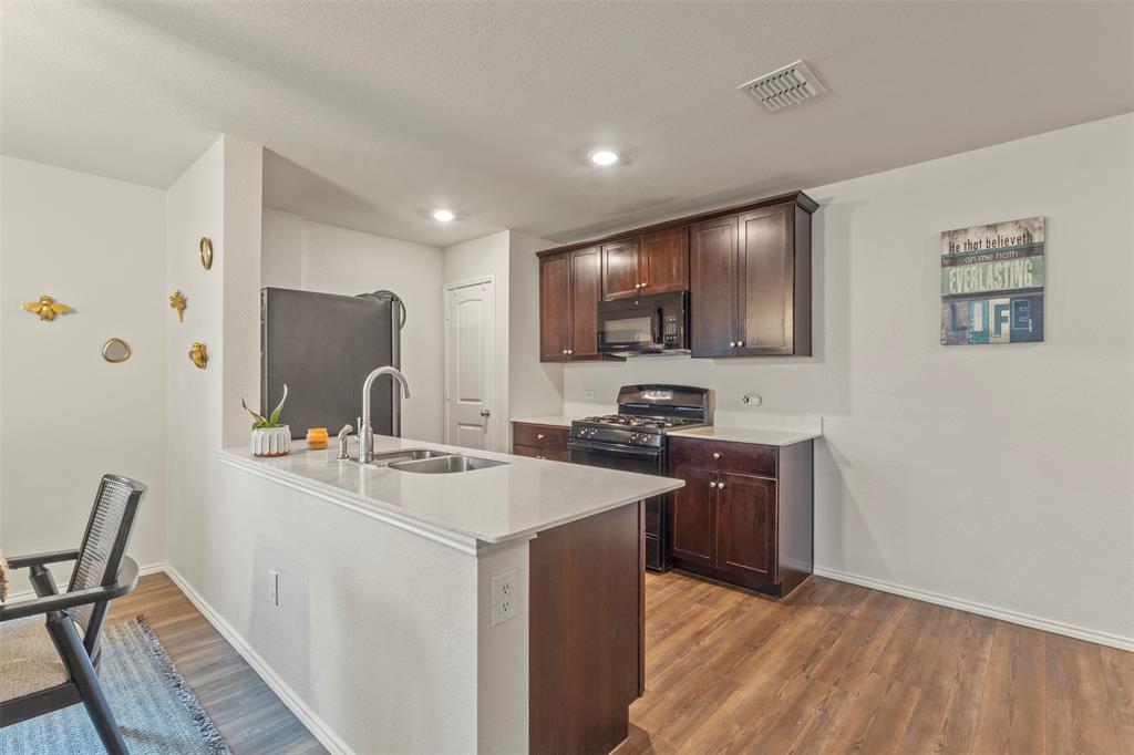 217 Anvil Drive Haslet, TX 76052 - Photo 7 of 18 a kitchen with stainless steel appliances a stove refrigerator sink and cabinets