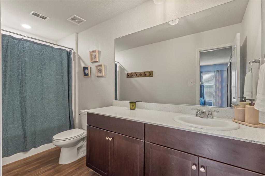 217 Anvil Drive Haslet, TX 76052 - Photo 10 of 18 a bathroom with a toilet sink a mirror and shower
