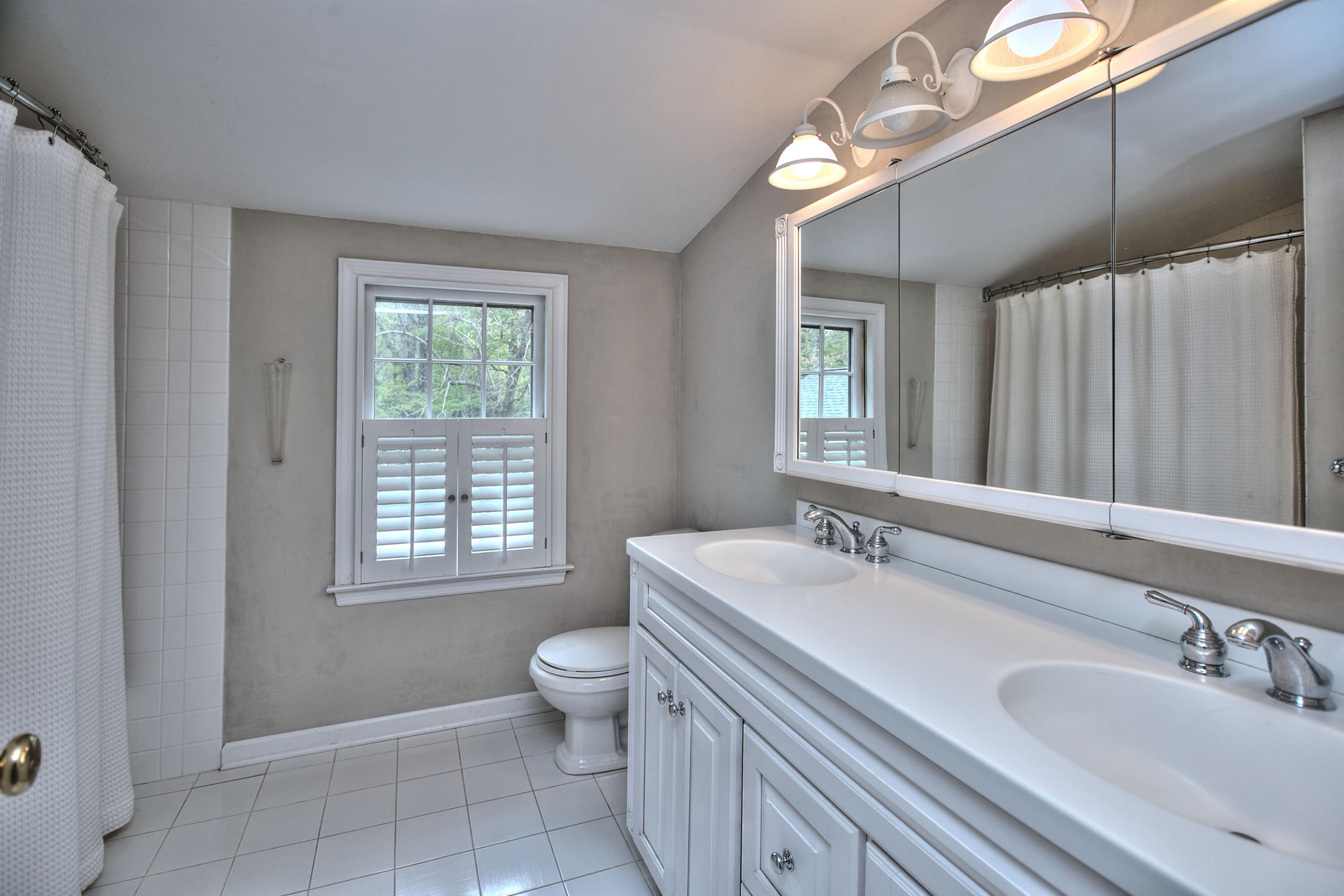 229 Smith Ridge Road New Canaan, CT 06840 - Photo 24 of 28 a bathroom with a sink a toilet and a mirror
