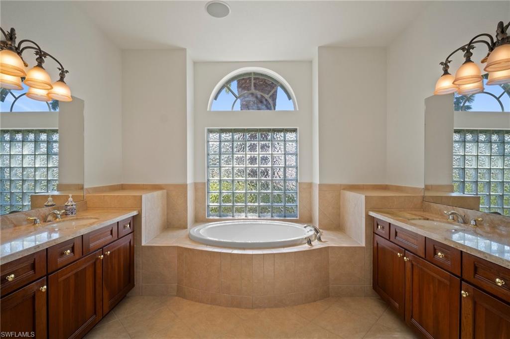 19415 La Serena Drive Estero, FL 33967 - Photo 20 of 49 a bathroom with a granite countertop bathtub a sink and a window