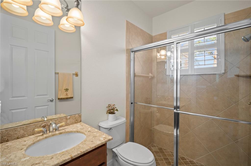 19415 La Serena Drive Estero, FL 33967 - Photo 25 of 49 a bathroom with a granite countertop sink toilet a mirror and shower