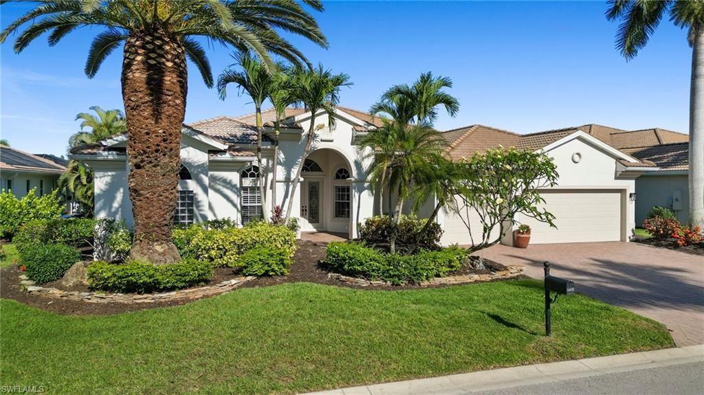 19415 La Serena Drive Estero, FL 33967 - Photo 3 of 49 a front view of a house with a garden