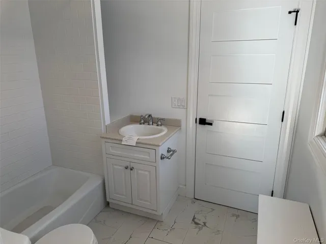 a bathroom with a sink a toilet and bathtub