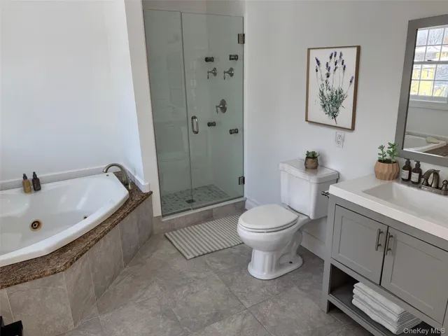 a bathroom with a granite countertop toilet a sink and bathtub