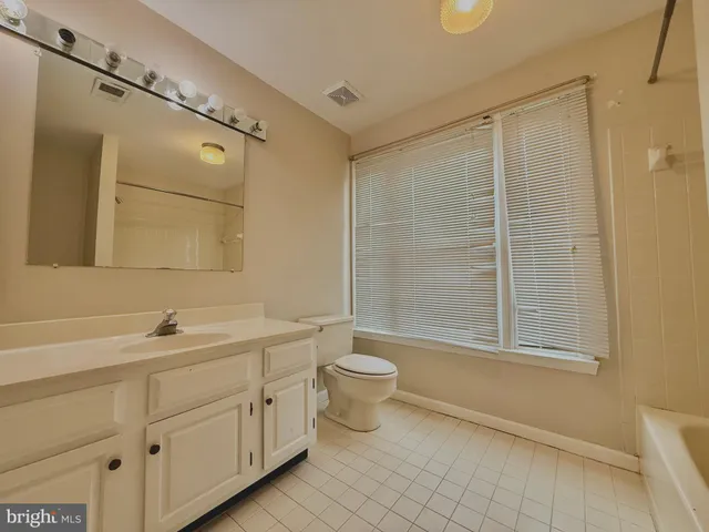 a view of a big room with windows and chandelier fan