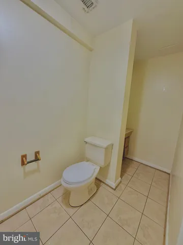 a bathroom with a granite countertop sink and a refrigerator