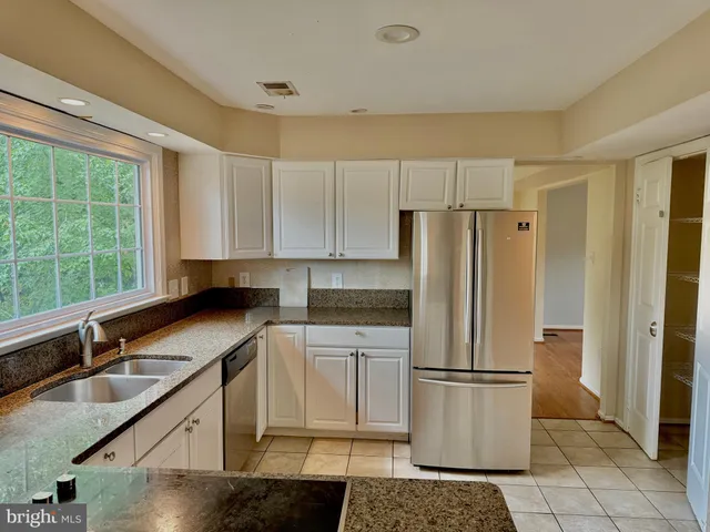 a kitchen with a refrigerator a sink and cabinets