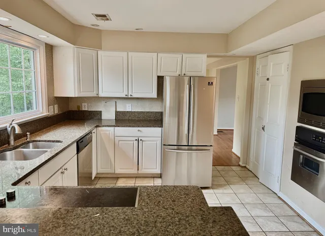 a kitchen with a refrigerator sink and cabinets