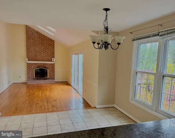 a view of an empty room with a fireplace and a window