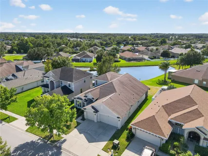 an aerial view of a house with a yard and lake view
