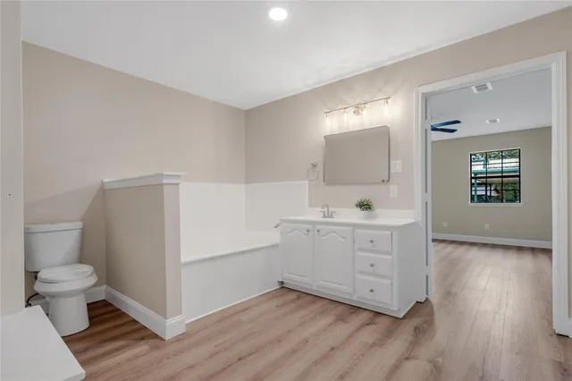 a bathroom with a double vanity sink toilet and mirror