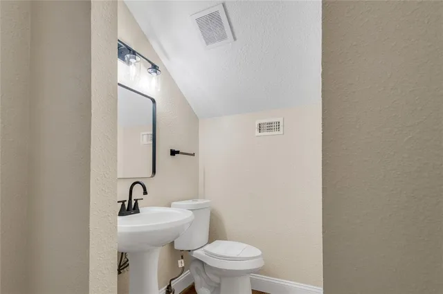 a bathroom with a toilet a sink and mirror