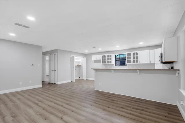 a view of empty room with wooden floor and window