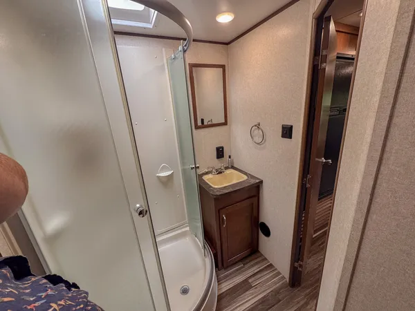 a bathroom with sink a mirror a toilet and a shower