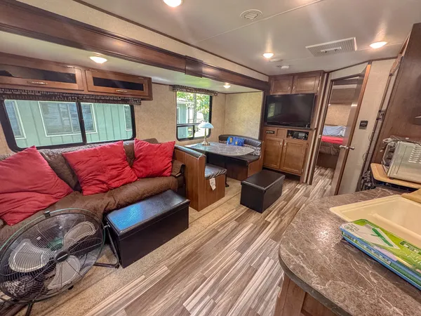 a living room with furniture a flat screen tv and wooden floor