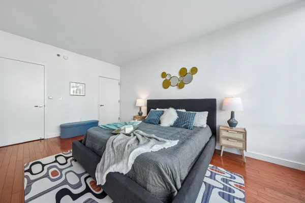 a bedroom with a bed and painting on the wall