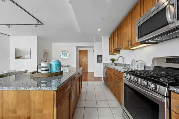 a kitchen with stainless steel appliances granite countertop a stove a sink and a microwave