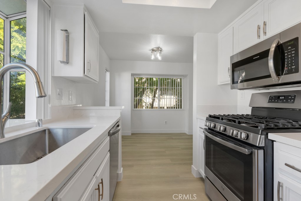 4201 Las Virgenes Road, Unit 206 Calabasas, CA 91302 - Photo 11 of 44 a kitchen with stainless steel appliances granite countertop a stove a microwave and a sink
