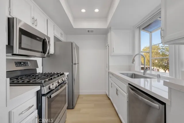 a kitchen with stainless steel appliances a sink stove and microwave