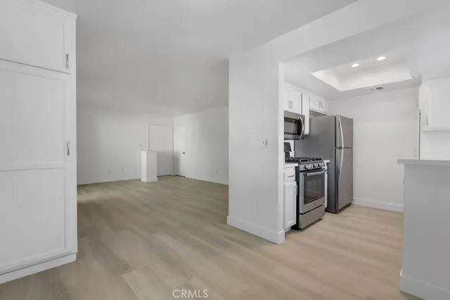 a view of a kitchen with refrigerator and a stove