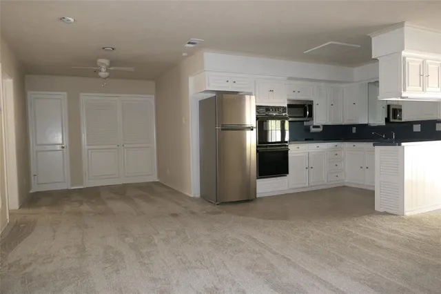 an empty room with closet and windows