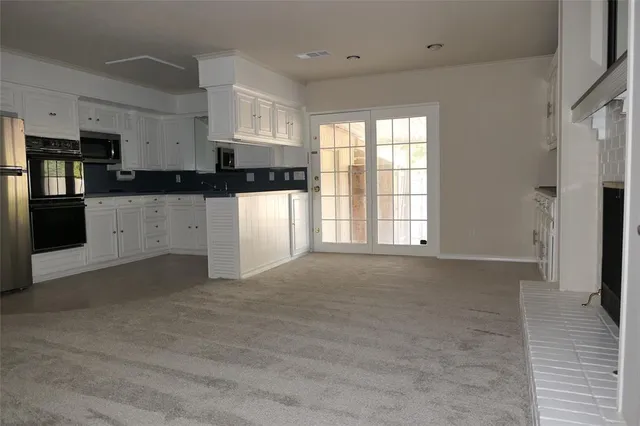a kitchen with a white cabinets and window