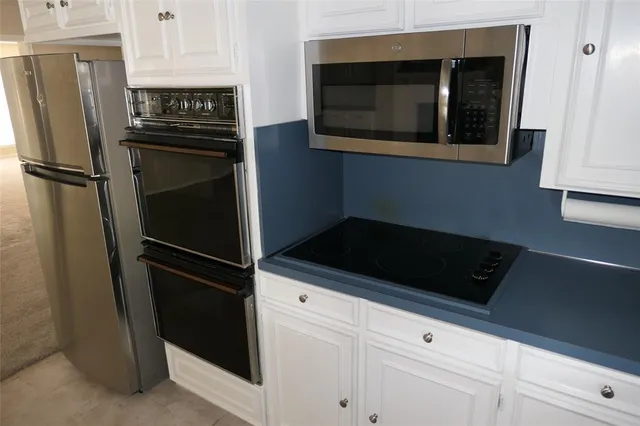 a kitchen with a refrigerator and cabinets