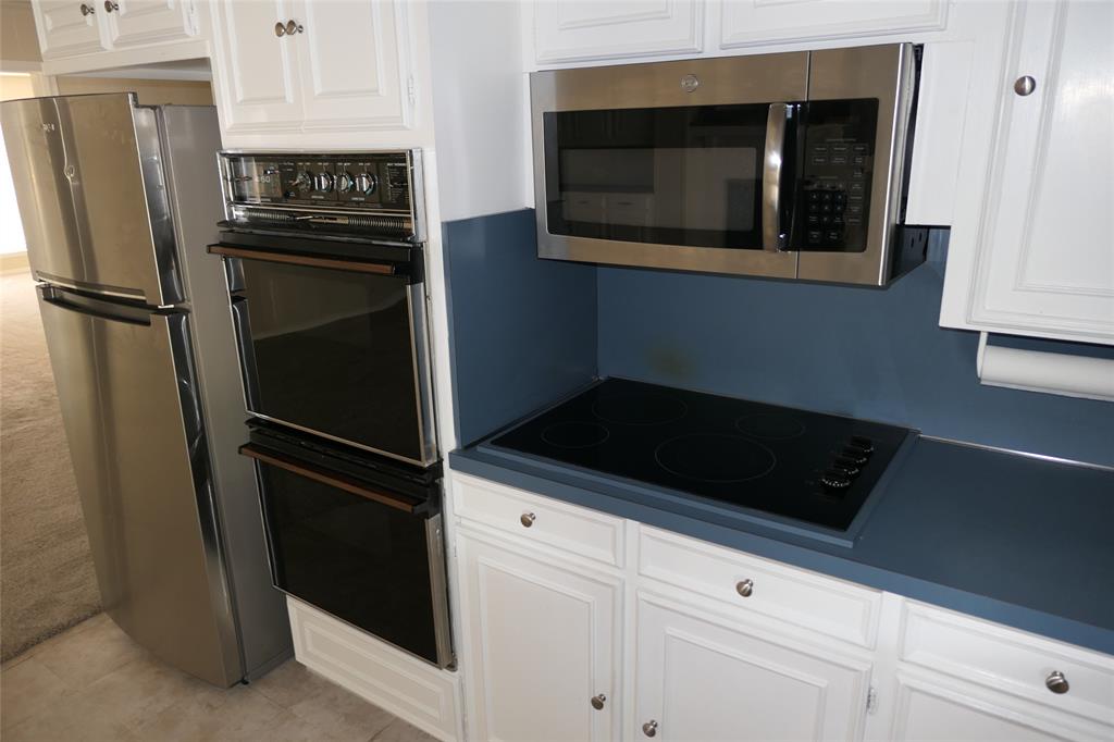 6317 Rincon Way Dallas, TX 75214 - Photo 16 of 32 a kitchen with a refrigerator and cabinets
