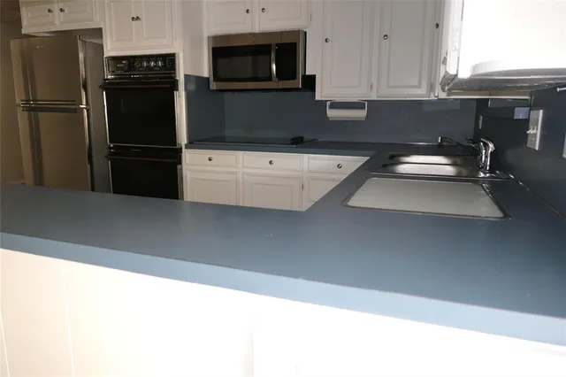 a kitchen with a sink and stainless steel appliances