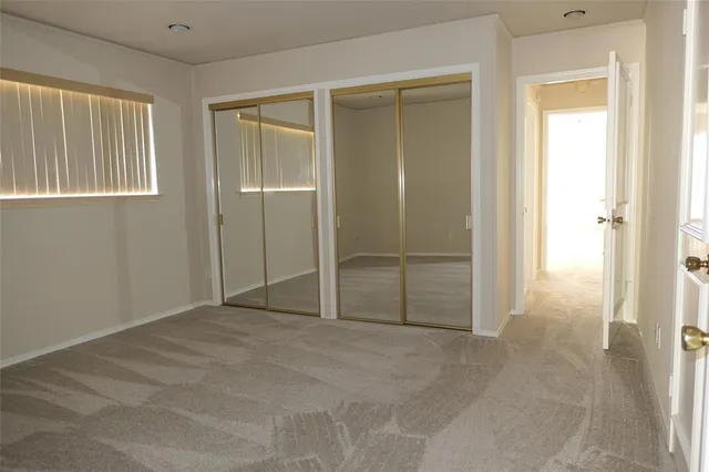 an empty room with closet and windows