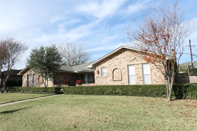 a front view of house with yard and trees around