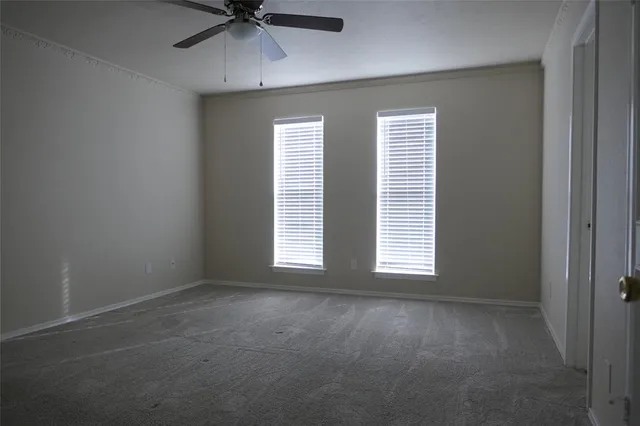 an empty room with a window and a fan