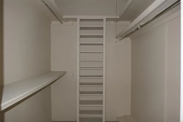 a view of walk in closet with empty racks