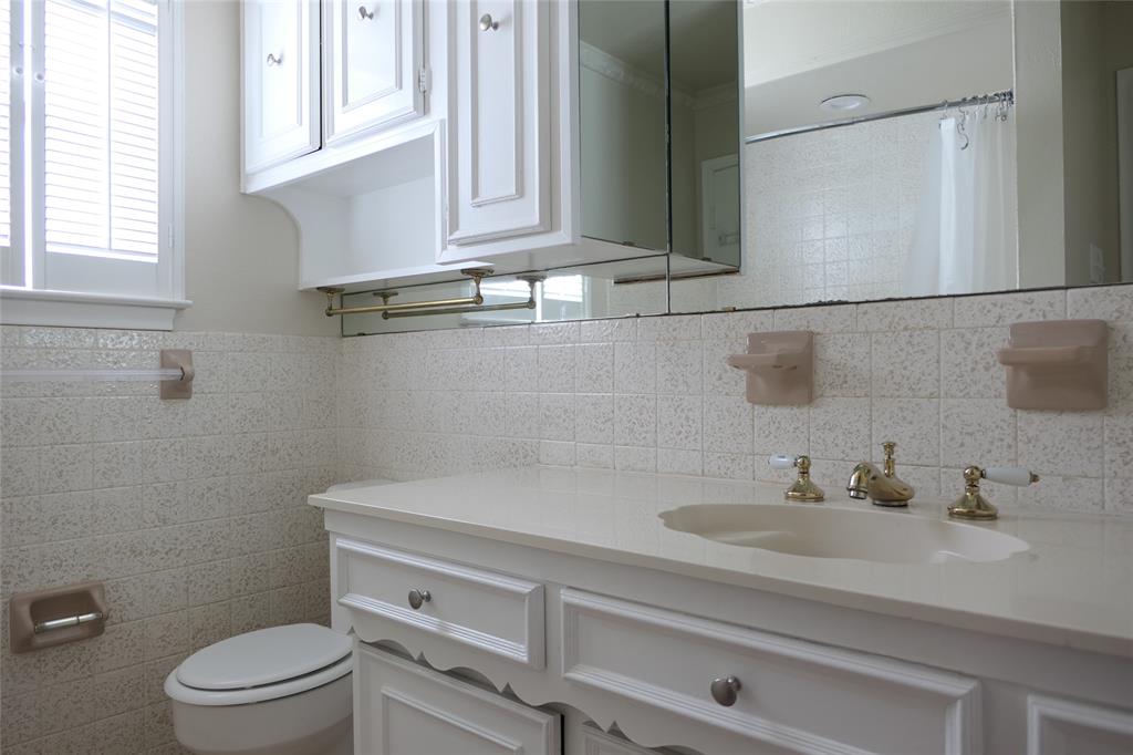 6317 Rincon Way Dallas, TX 75214 - Photo 26 of 32 a bathroom with a sink a toilet and vanity