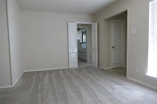 an empty room with closet and windows