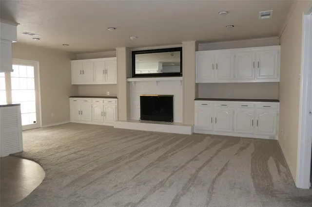 a view of empty room with wooden floor and fireplace