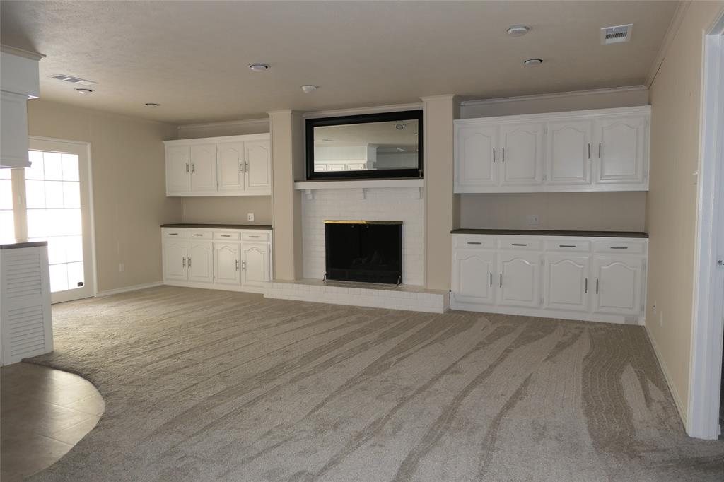 6317 Rincon Way Dallas, TX 75214 - Photo 10 of 32 a view of empty room with wooden floor and fireplace
