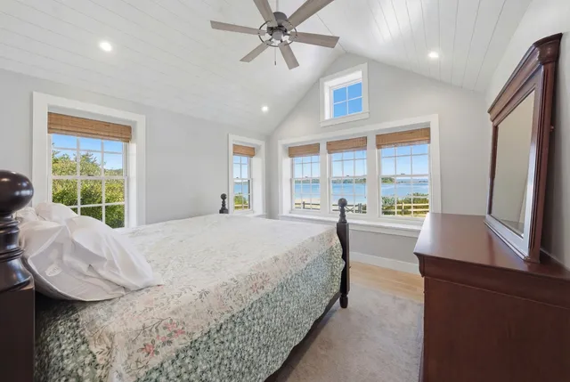 a spacious bedroom with a bed a table and windows