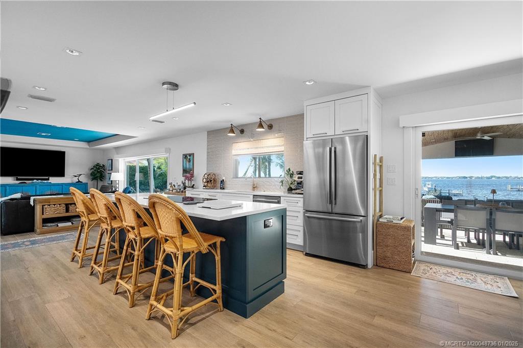 1433 Southeast Riverside Drive Stuart, FL 34996 - Photo 14 of 64 a kitchen with stainless steel appliances granite countertop a refrigerator a stove a sink dishwasher and a dining table with wooden floor